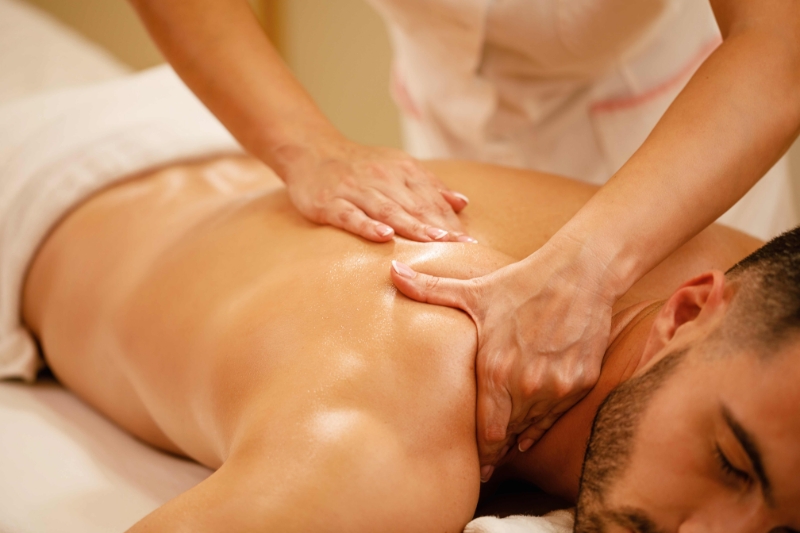 Therapist applying pressure during a deep tissue oil massage.